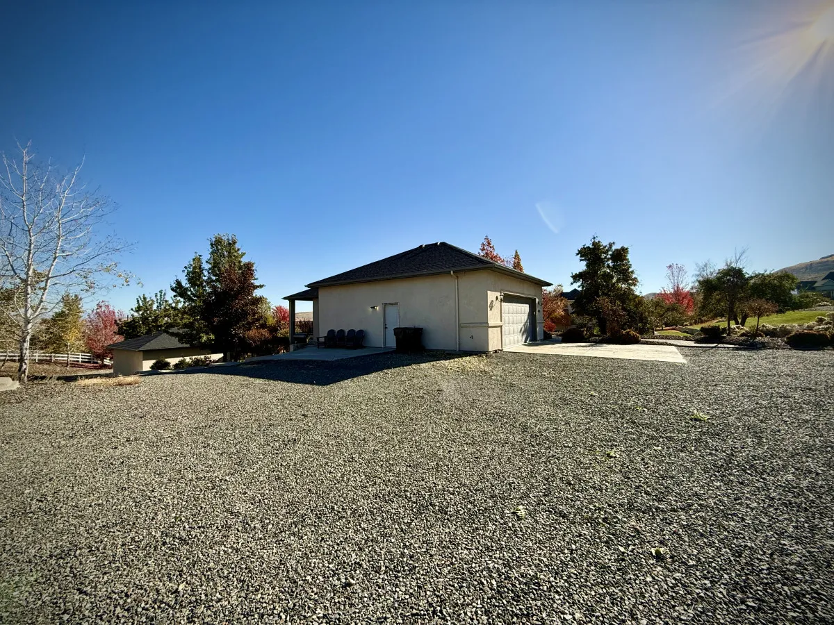 This image features the house exterior with a spacious driveway and well-maintained landscaping. The environment exudes peace and tranquility, with open spaces ideal for a relaxing retreat after a round of golf.
