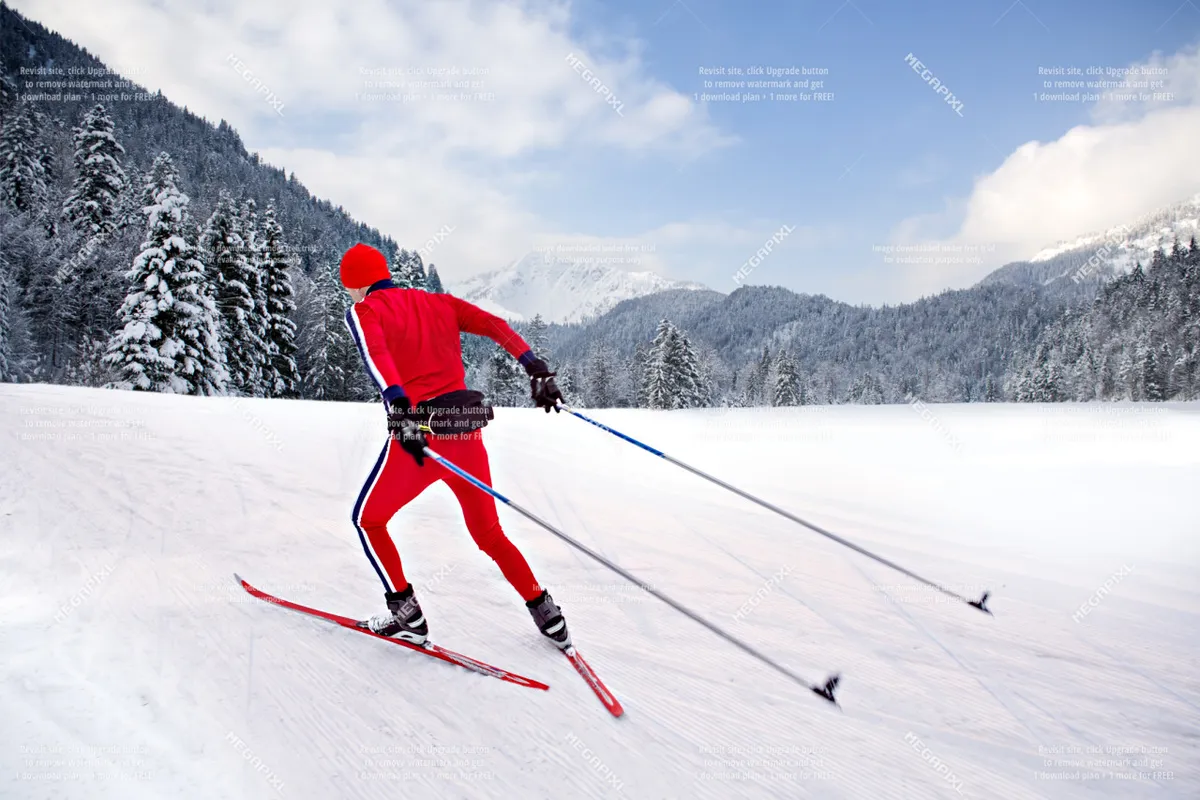 A cross-country skier glides through a snow-covered landscape framed by pine trees, with rolling mountains in the background. The untouched snow and open sky evoke a sense of winter adventure and pristine wilderness.